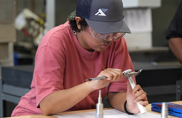 Student learns precision measuring during the Manufacturing Academy program.